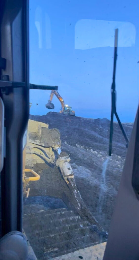 Excavator clearing land with heavy machinery to prepare the site for development.